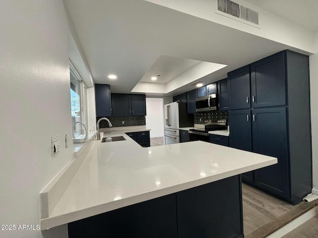 5431 W Cholla St, Glendale, AZ 85304 - kitchen featuring appliances with stainless steel finishes, light countertops, visible vents, decorative backsplash, and a sink