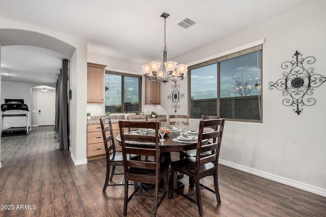 dining area with baseboards, visible vents, arched walkways, and dark wood-style flooring