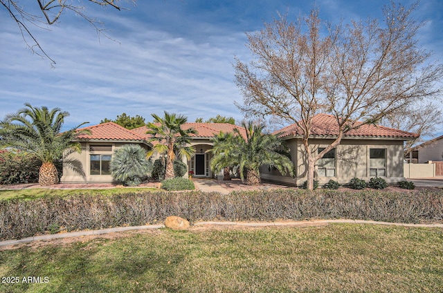 mediterranean / spanish-style home with a front lawn