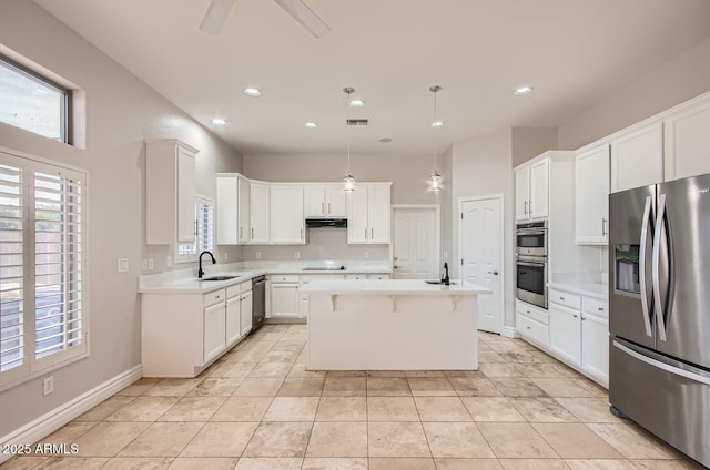 kitchen featuring pendant lighting, sink, appliances with stainless steel finishes, white cabinetry, and a kitchen island