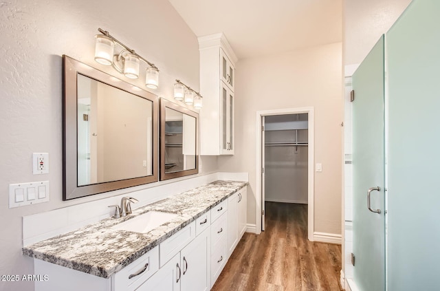 bathroom featuring vanity, wood-type flooring, and a shower with shower door