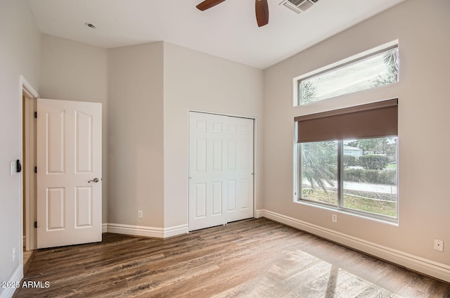 unfurnished bedroom featuring wood-type flooring, ceiling fan, and a closet