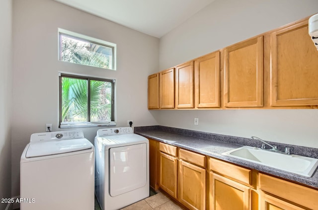 washroom with cabinets, sink, washing machine and dryer, and light tile patterned floors