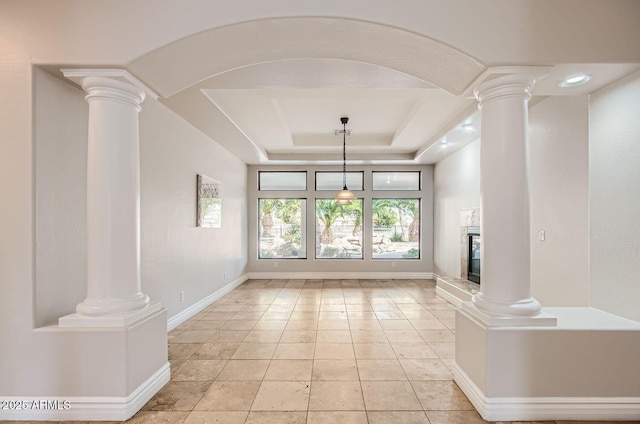 unfurnished living room featuring decorative columns and light tile patterned floors