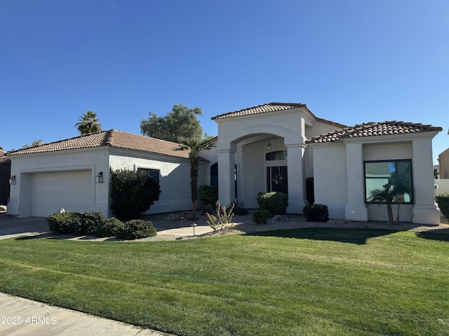 mediterranean / spanish-style house featuring a garage and a front lawn