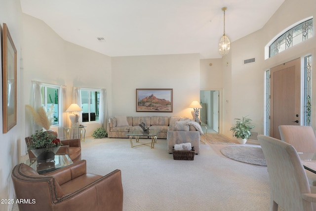 living room featuring a towering ceiling and carpet floors