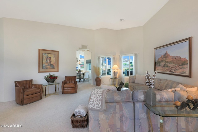 carpeted living room with a towering ceiling