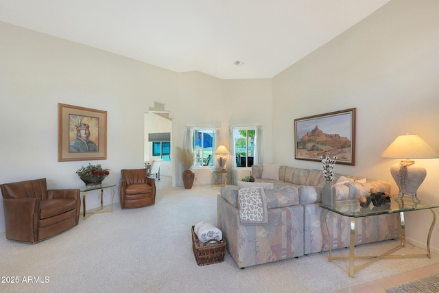 living room with a high ceiling and carpet flooring