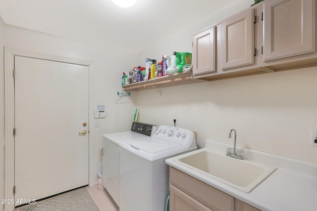 clothes washing area featuring sink, cabinets, and independent washer and dryer