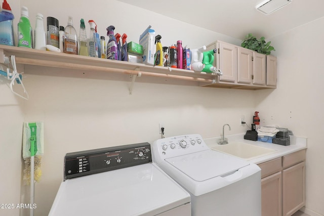 clothes washing area with sink, cabinets, and washer and dryer