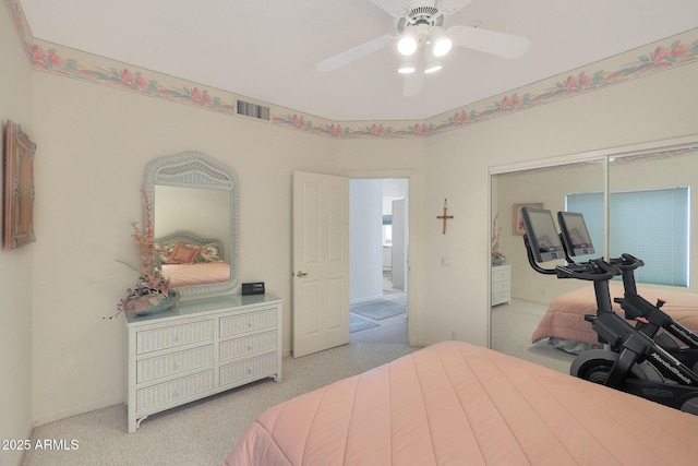 bedroom with light carpet, ceiling fan, and a closet