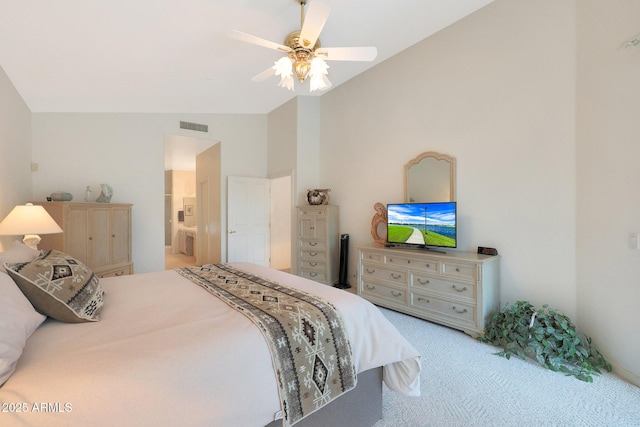 carpeted bedroom with ceiling fan, connected bathroom, and vaulted ceiling