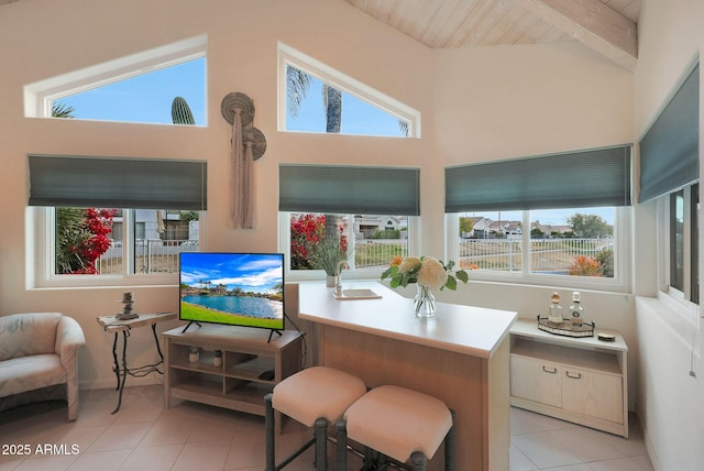 interior space featuring vaulted ceiling with beams, light tile patterned floors, and a healthy amount of sunlight