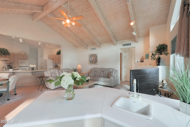 kitchen featuring sink, white appliances, track lighting, wooden ceiling, and beamed ceiling