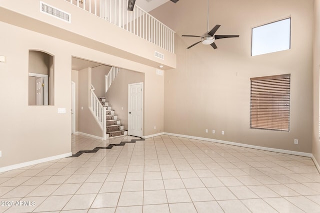 7029 S Golfside Ln, Phoenix, AZ 85042 - unfurnished living room featuring a towering ceiling, a ceiling fan, stairway, and light tile patterned floors