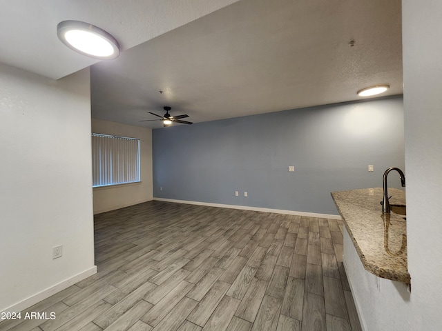 unfurnished living room with ceiling fan and light hardwood / wood-style flooring