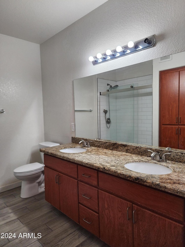 bathroom with walk in shower, vanity, toilet, and wood-type flooring