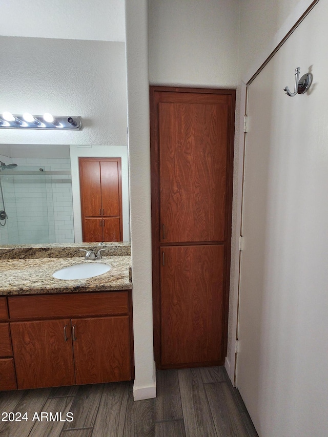 bathroom featuring wood-type flooring, vanity, and a shower with shower door