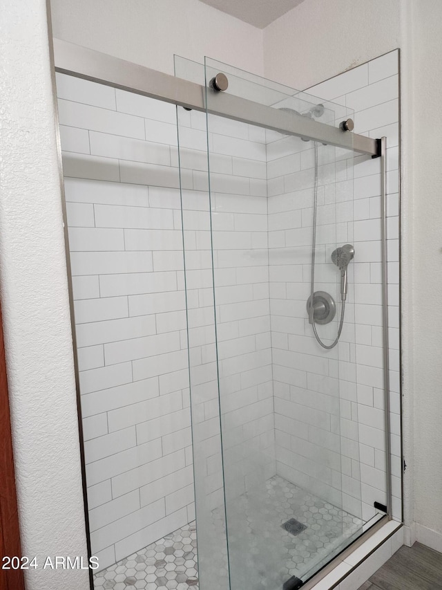 bathroom with hardwood / wood-style flooring and an enclosed shower