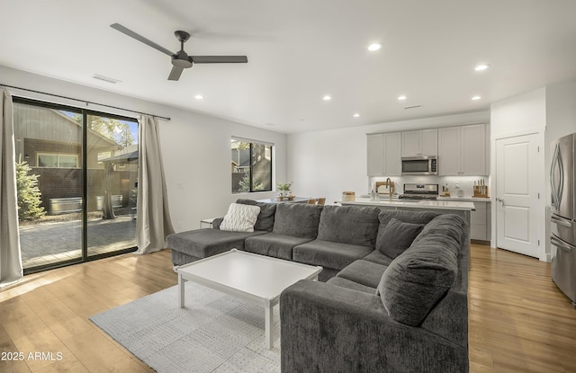 living room featuring recessed lighting, ceiling fan, and light wood-type flooring