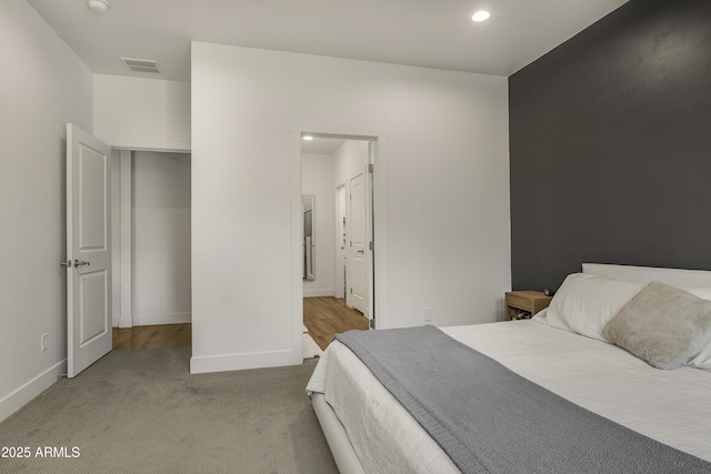 carpeted bedroom featuring recessed lighting, baseboards, visible vents, and ensuite bathroom