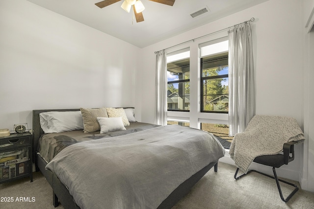 bedroom featuring visible vents, a ceiling fan, and light carpet