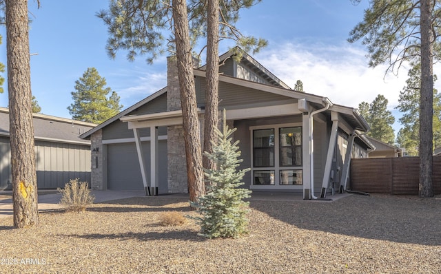 view of front of property featuring fence, an attached garage, concrete driveway, and a chimney