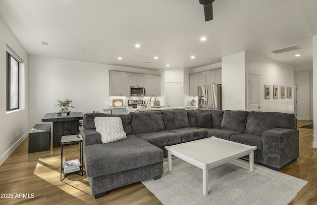 living room with recessed lighting, ceiling fan, visible vents, and light wood finished floors