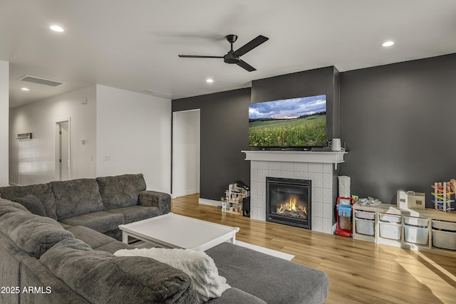 living room featuring visible vents, wood finished floors, ceiling fan, recessed lighting, and a tile fireplace
