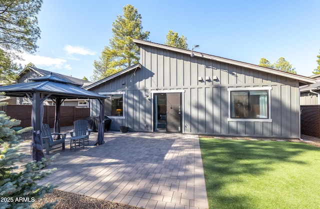 rear view of house featuring a gazebo, a patio, board and batten siding, and a yard