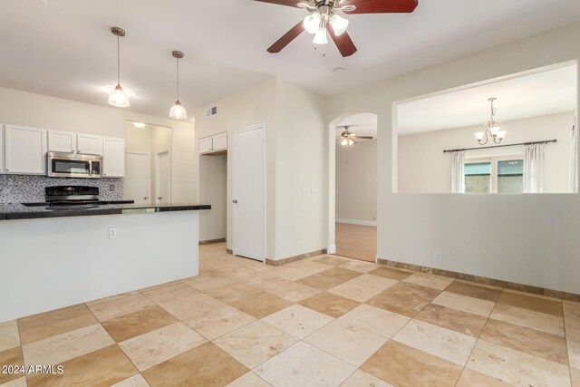 kitchen featuring black / electric stove, white cabinetry, sink, kitchen peninsula, and pendant lighting