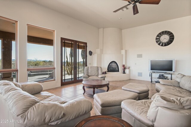 tiled living room featuring ceiling fan and a large fireplace