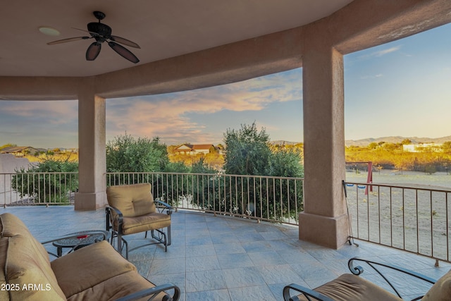 patio terrace at dusk featuring ceiling fan