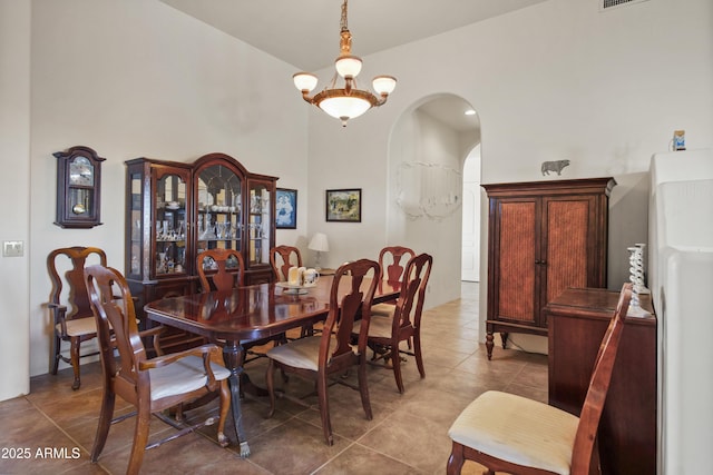 tiled dining room with a chandelier