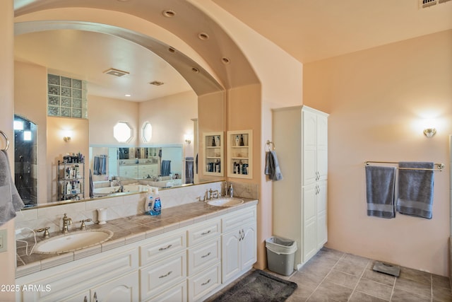 bathroom with tile patterned flooring, a washtub, and vanity