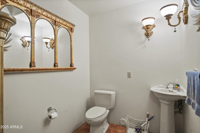 bathroom with sink, toilet, and tile patterned flooring