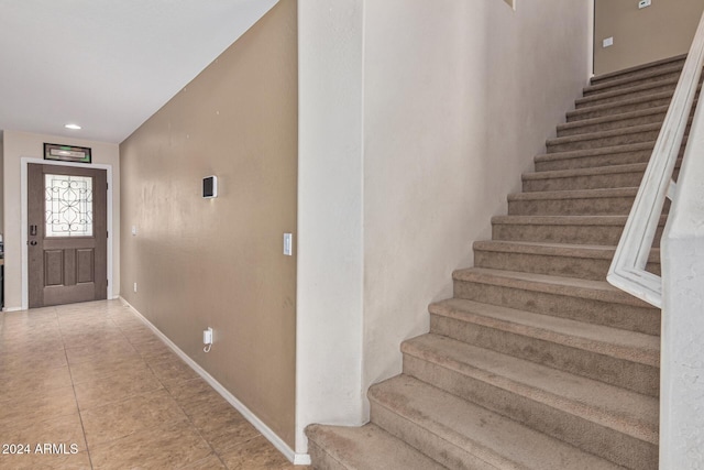 staircase featuring baseboards and tile patterned floors