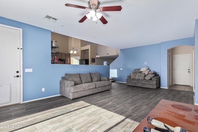 living area featuring arched walkways, wood finish floors, visible vents, baseboards, and a ceiling fan