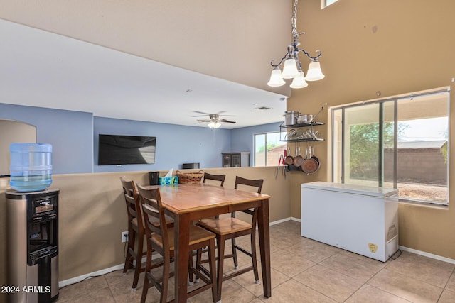 dining room with light tile patterned floors, baseboards, and ceiling fan with notable chandelier