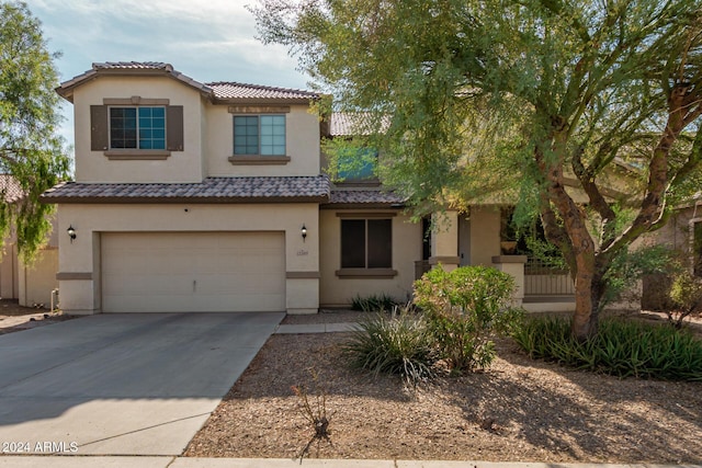 view of front facade with a garage, concrete driveway, a tiled roof, and stucco siding