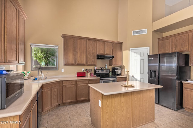 kitchen featuring light tile patterned floors, visible vents, appliances with stainless steel finishes, a sink, and under cabinet range hood