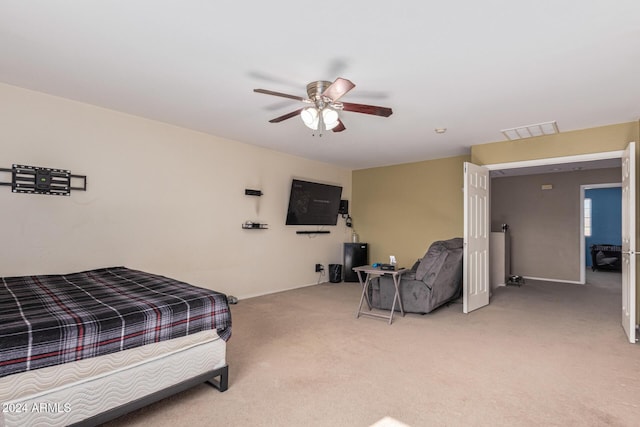bedroom featuring visible vents, a ceiling fan, and light colored carpet