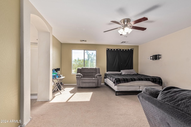 bedroom with carpet floors, a baseboard radiator, visible vents, and arched walkways