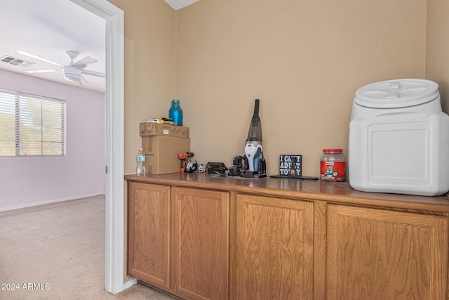 interior details with carpet floors, baseboards, visible vents, and a ceiling fan