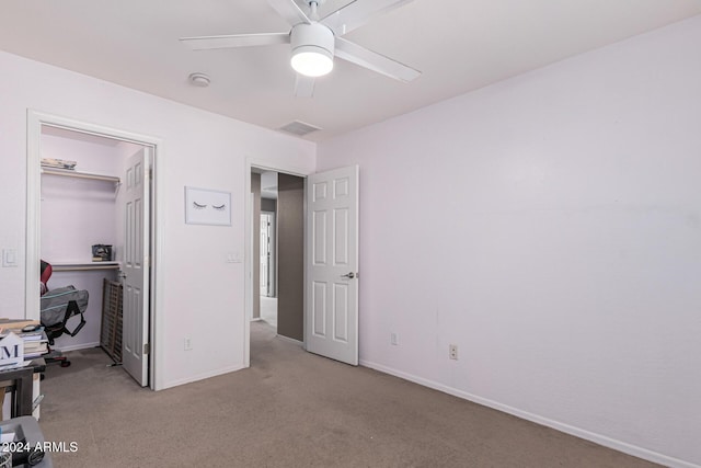 unfurnished bedroom featuring baseboards, visible vents, ceiling fan, carpet floors, and a closet