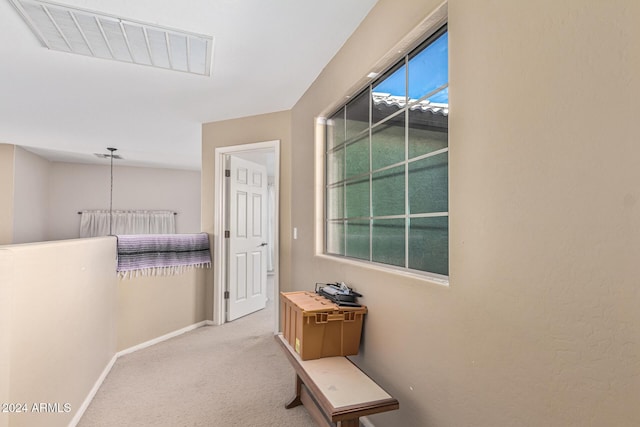 hall with carpet floors, visible vents, and baseboards