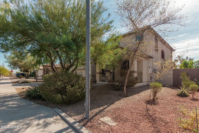 view of side of home featuring fence and stucco siding