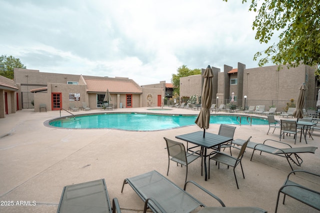 community pool featuring fence and a patio