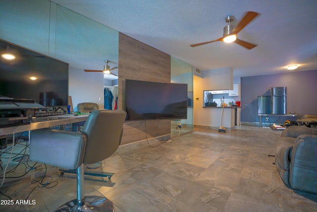 living area featuring a ceiling fan and wooden walls
