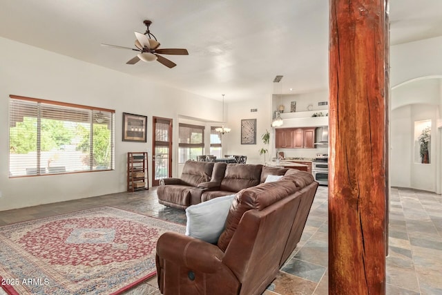 living room with ceiling fan with notable chandelier